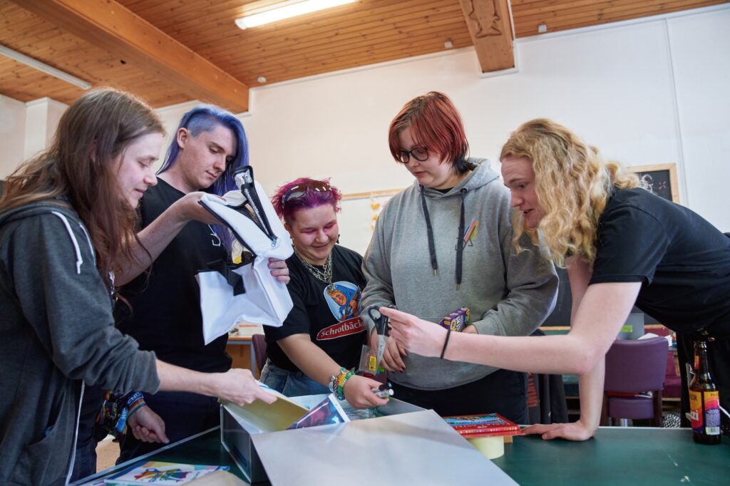 Jugendgruppe von VIDA Landsberg beim Auspacken einer Queerstart Box